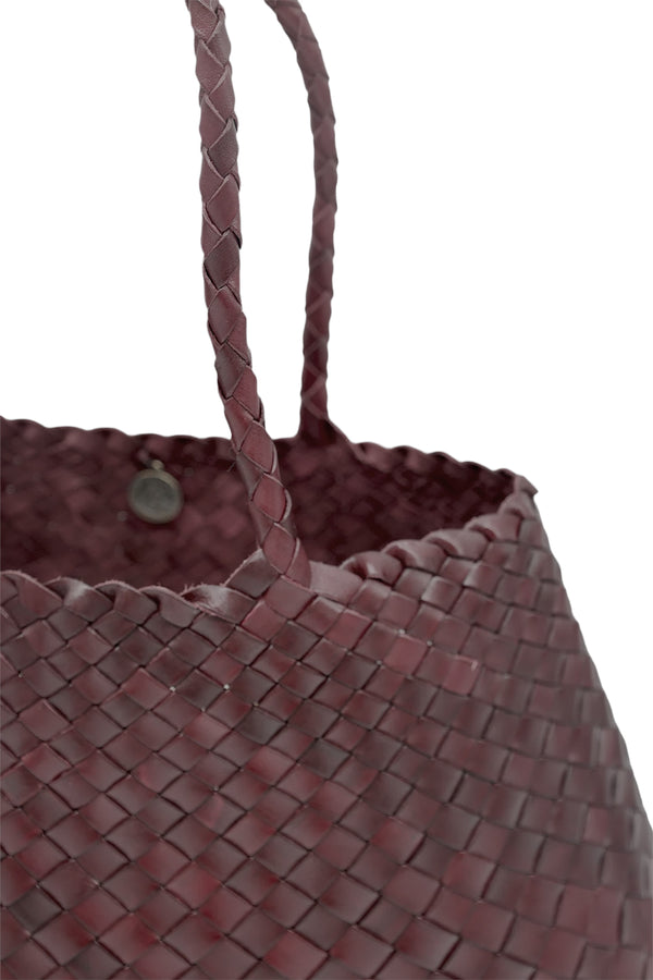 Close-up view of Dragon Diffusion woven leather tote bag in dark red, shown against a plain white background.