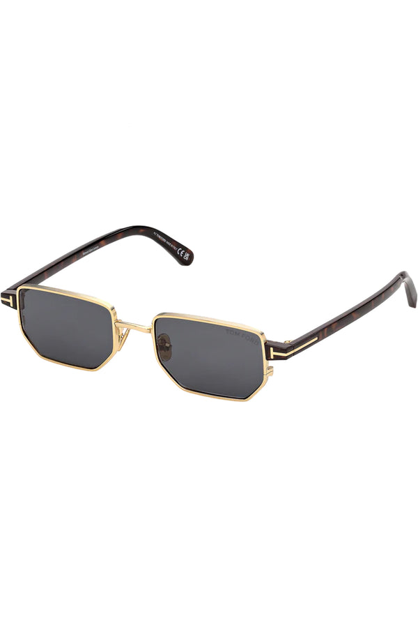 Rotated view of Tom Ford rectangular sunglasses in gray with dark tortoise and metal frame and gold T details, shown against a plaid white background.