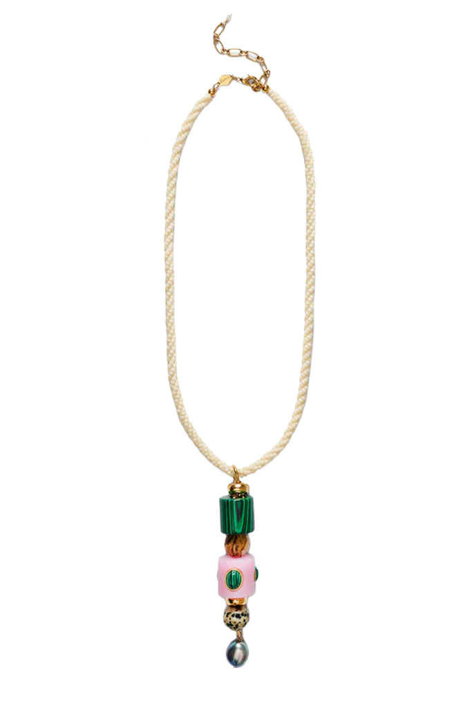 A bohemian-style beaded necklace featuring a cream-colored braided rope cord, gold-tone metal hardware, a green cylindrical bead, a pink oval bead with a green center, and a dangling iridescent bead.